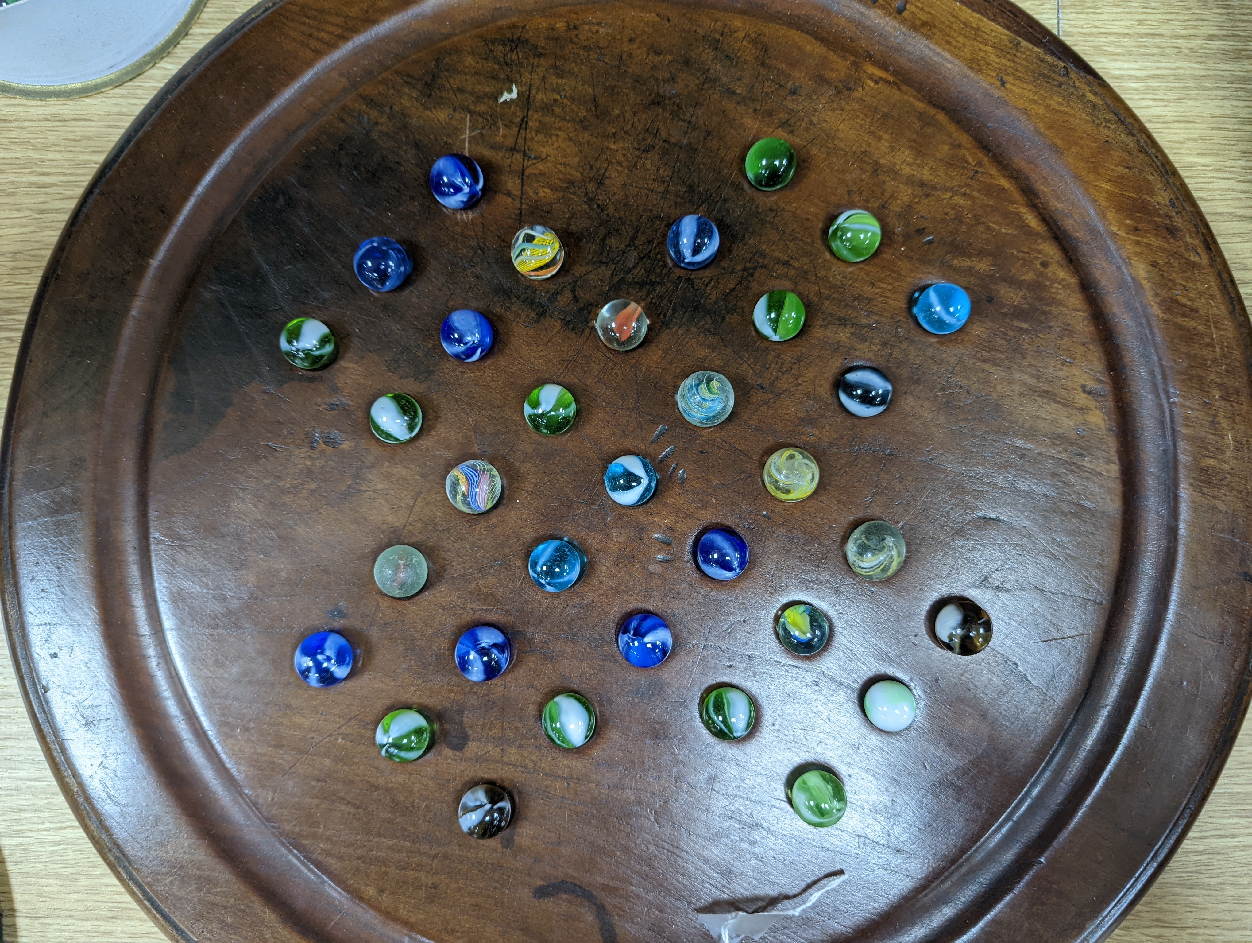 A collection of glass marbles and a mahogany solitaire board 45cm